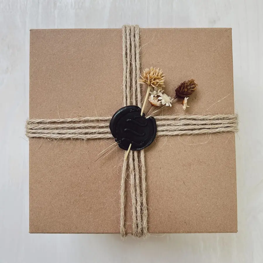 Presente embrulhado em papel kraft com barbante e flor seca